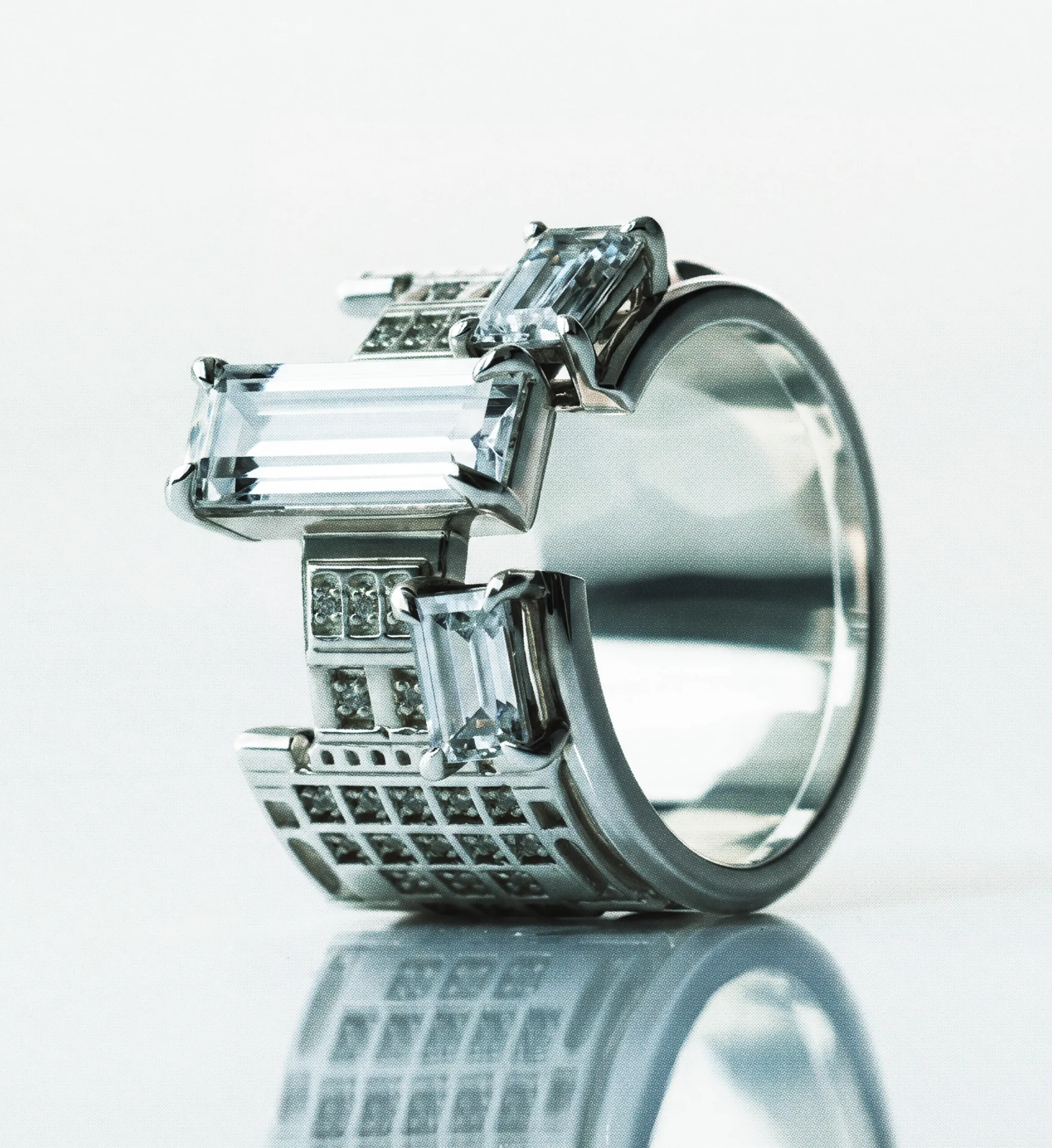 Sculptural white gold ring whose stepped silhouette echoes the Palace of Culture and Science tower, set with step-cut diamonds, photographed on white